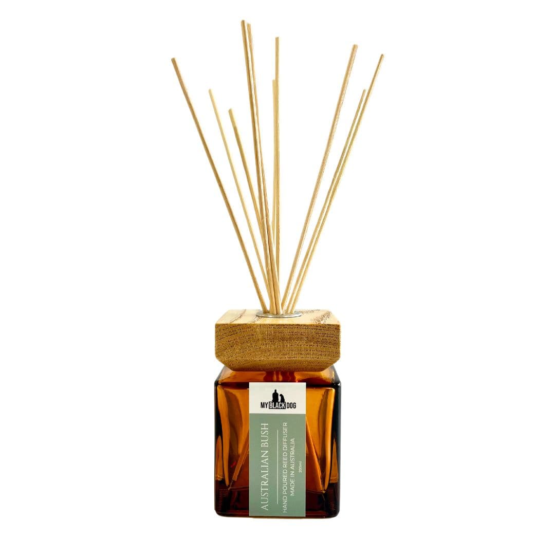 Reed diffuser with wooden cap and amber glass bottle on a white background