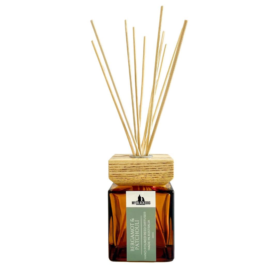 Reed diffuser with wooden lid and sticks on a white background