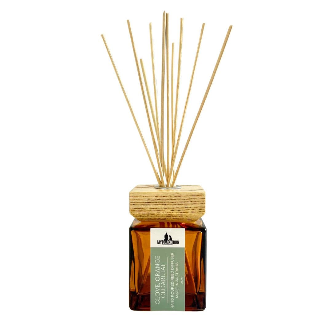 Reed diffuser with wooden sticks and an amber bottle on a white background