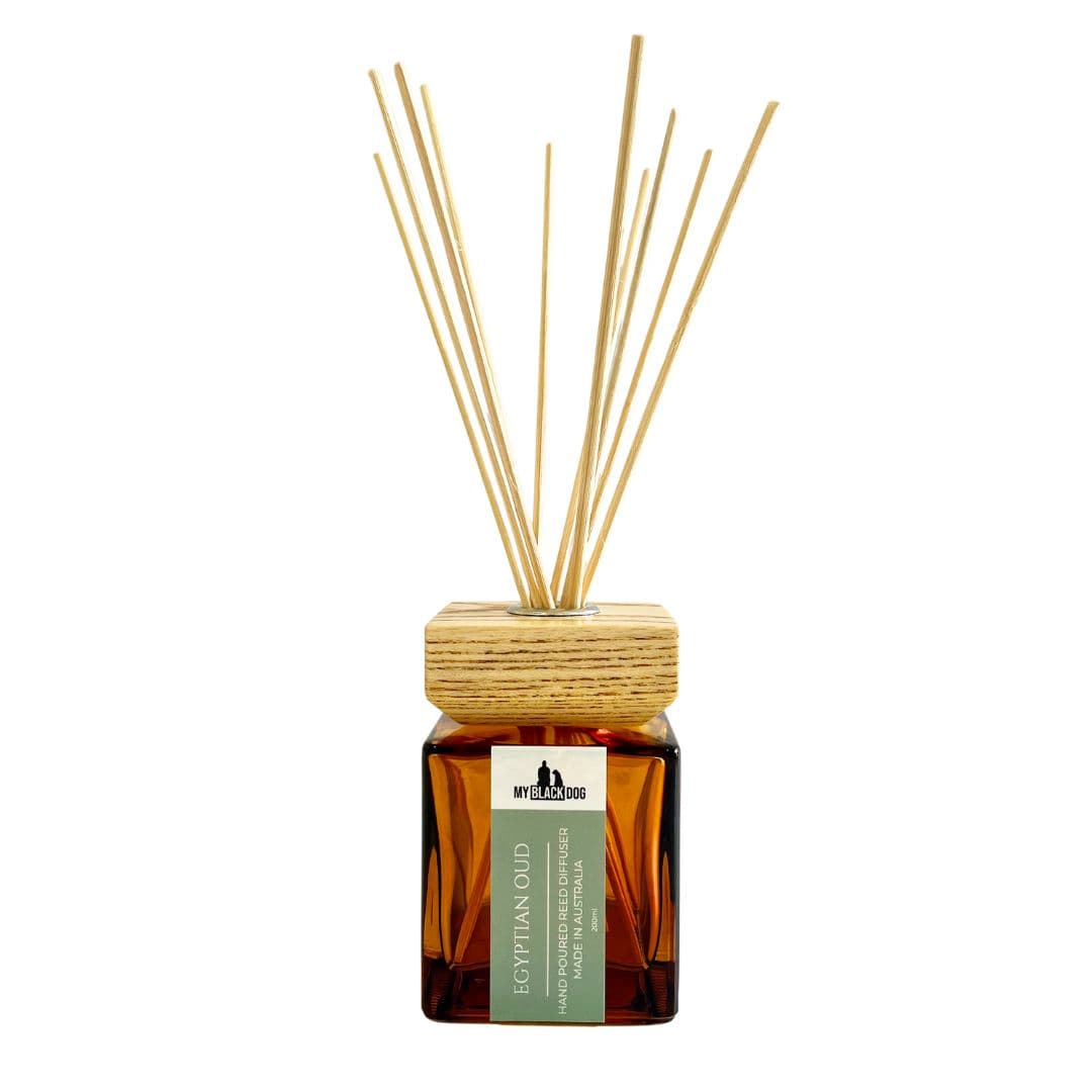 Reed diffuser with wooden cap and sticks on a white background