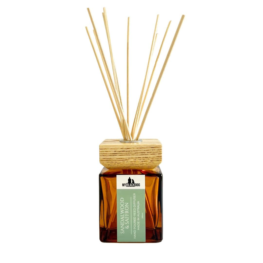 My Black Dog sandalwood and saffron scented reed diffuser in a square amber bottle with wooden cap on a white background