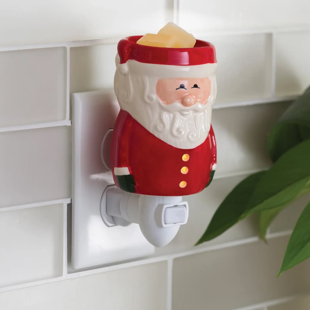 Santa Claus wall plug-in melt warmer with plant leaves behind it.