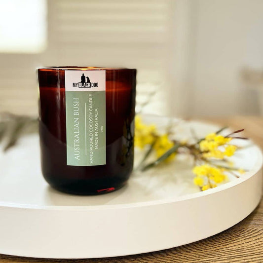 My Black Dog Australian Bush CocoSoy Candle sitting on white tray with wattle