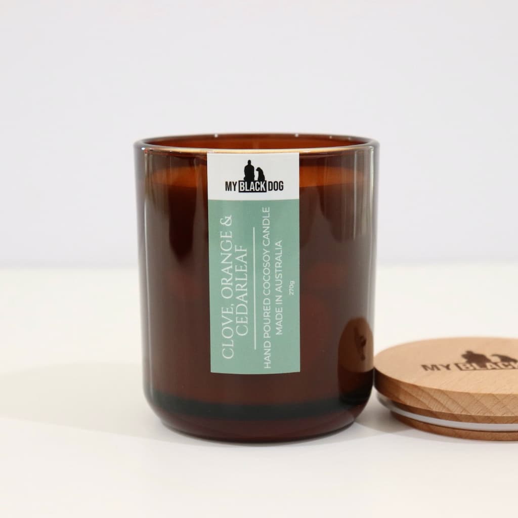 My Black Dog Clove, Orange & Cedarleaf CocoSoy Candle in an amber jar with a natural timber lid