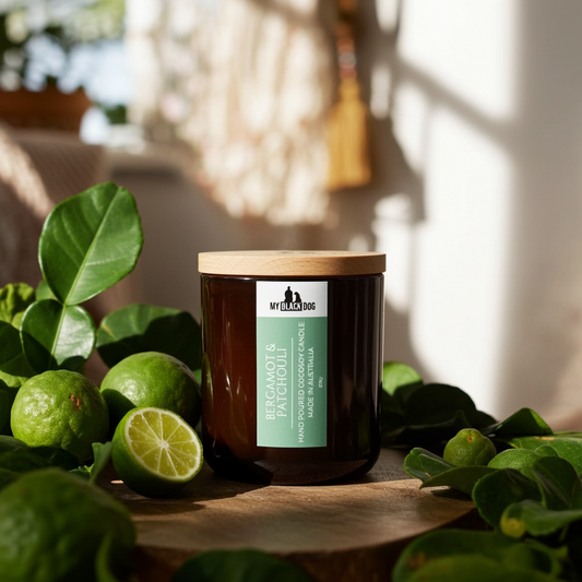 Bergamot and Patchouli scented candle sitting on a board with bergamot surrounding it.