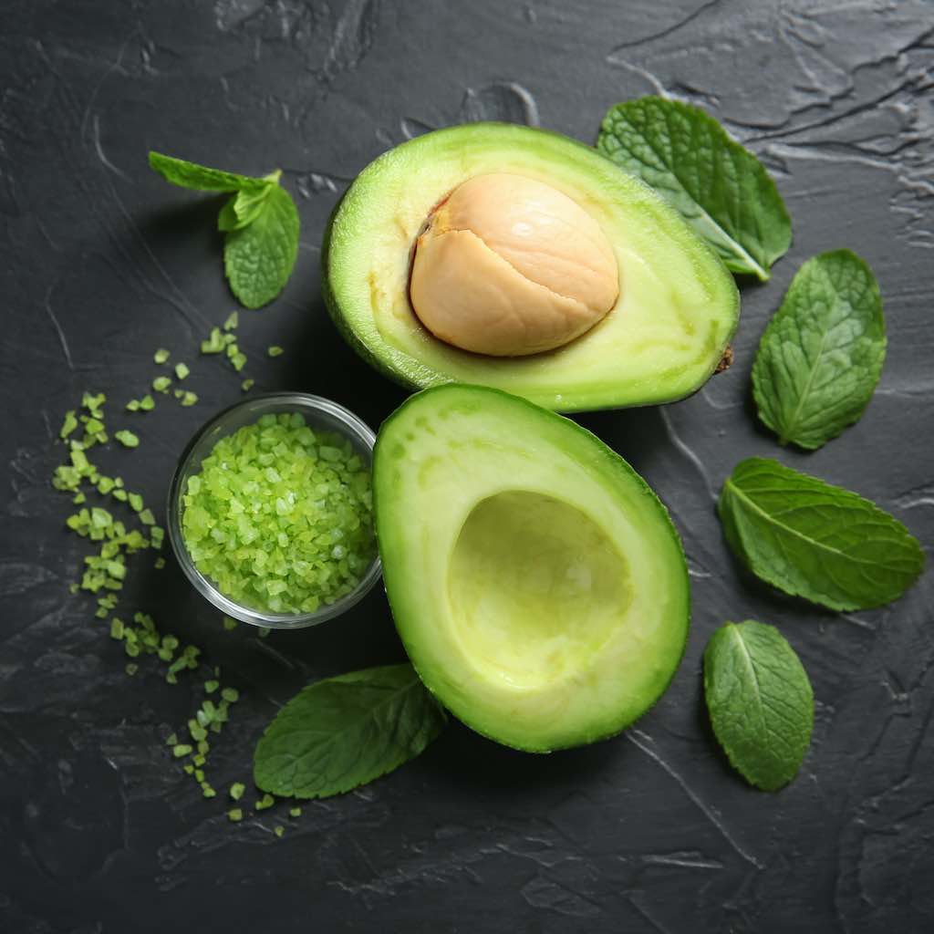 Cut open avocado with mint leaves