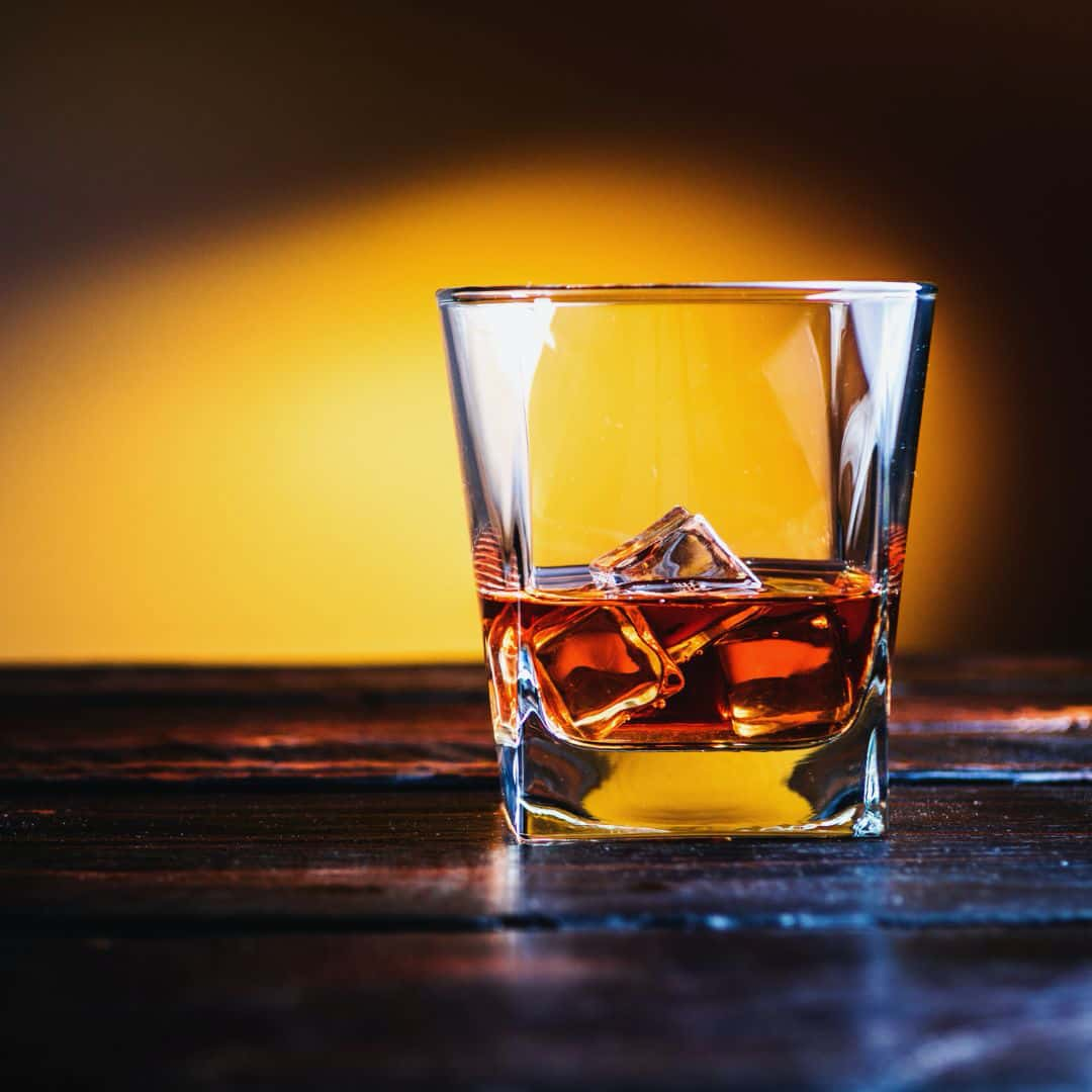 A glass of bourbon with cubes of ice