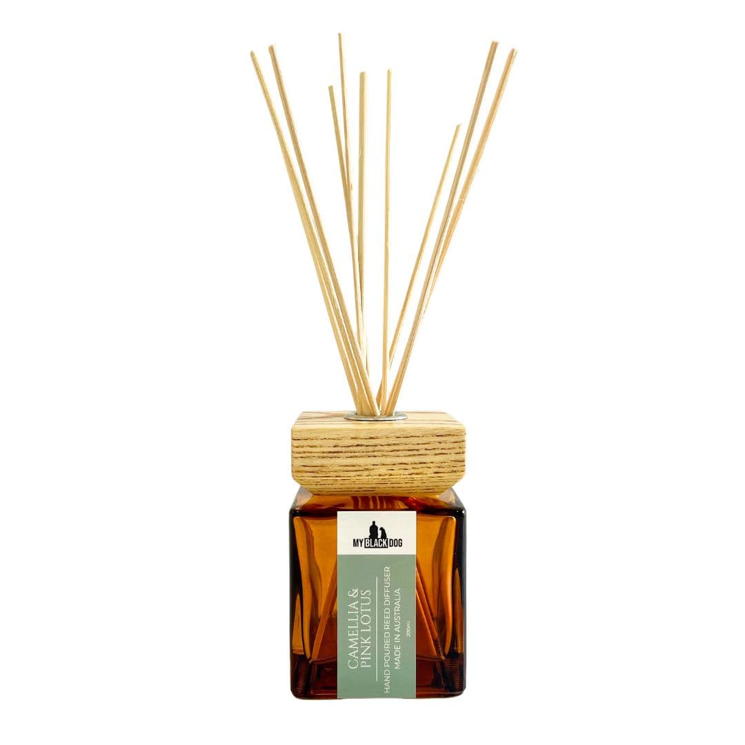 Reed diffuser with wooden sticks in an amber bottle on a white background