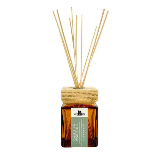 Reed diffuser with wooden sticks in an amber bottle on a white background