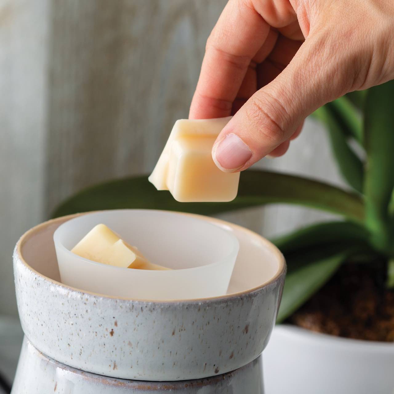 Wax Melt being put into a silicone melt warmer flip dish